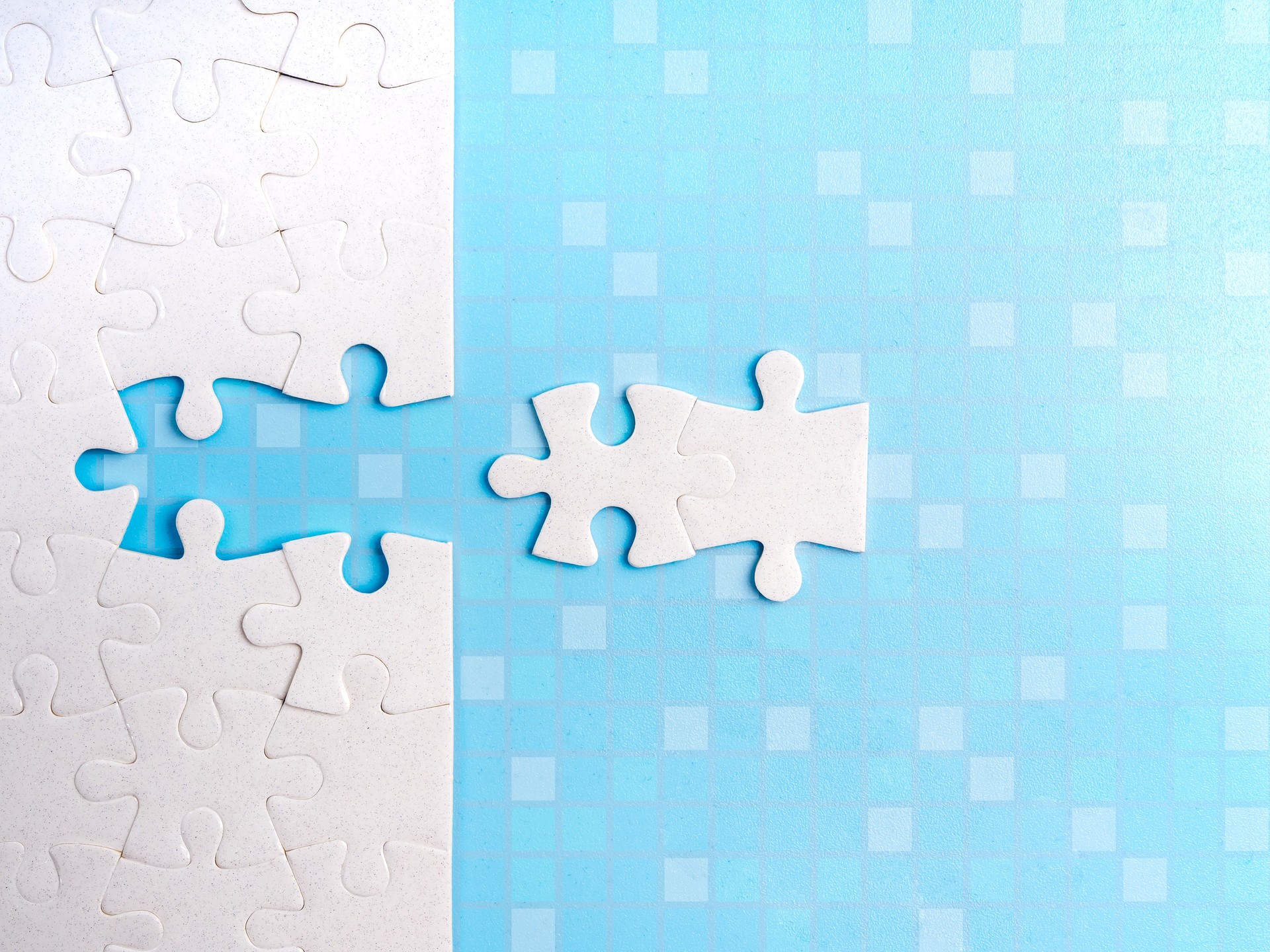 HR, human resources, recruitment and hiring, partnership, solution technology, solving problems, business data concept. The last two white jigsaw puzzle piece isolated on blue digital grid background.